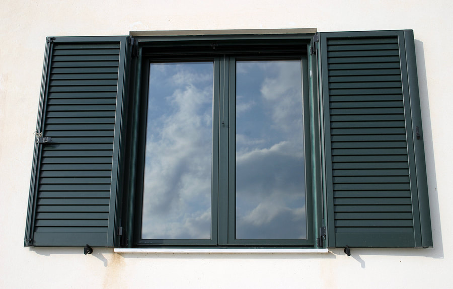 glass window with green shutters